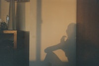 a shadow of a person sitting in a room