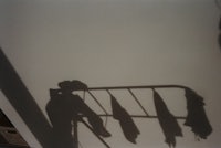 a shadow of a clothes rack on a wall